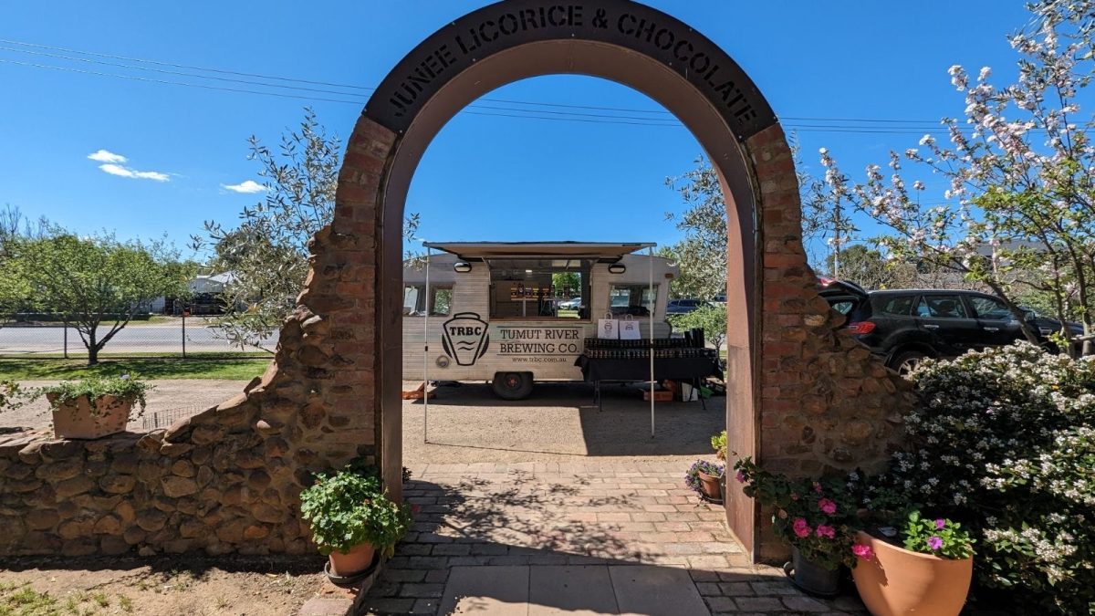 The Tumut Brewery truck set up to serve, seen through the entrance archway to the Junee Licorice and Chocolate Factory. 