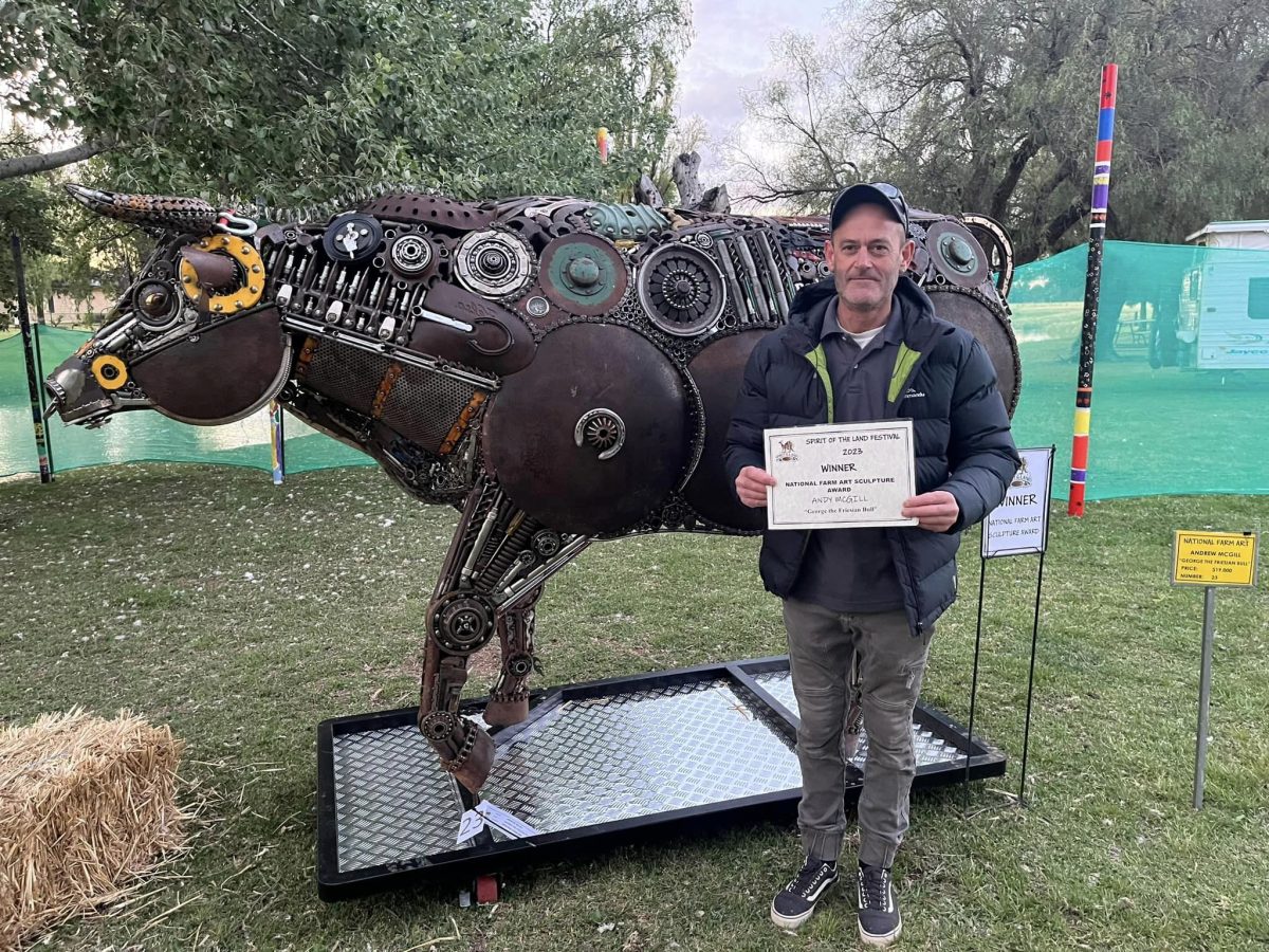 sculptor with his award and metal bull creation