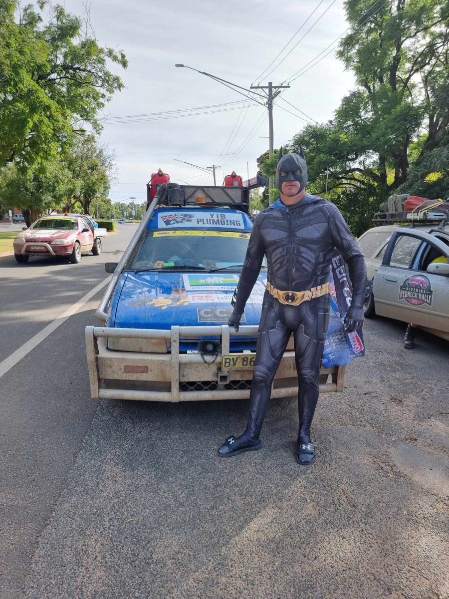 Guy in batman suit in front of car