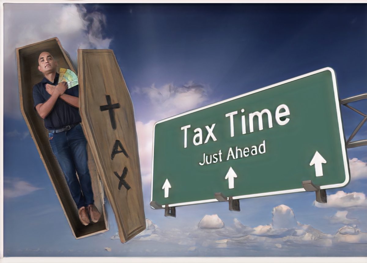 Oliver Jacques in a coffin with a tax time sign