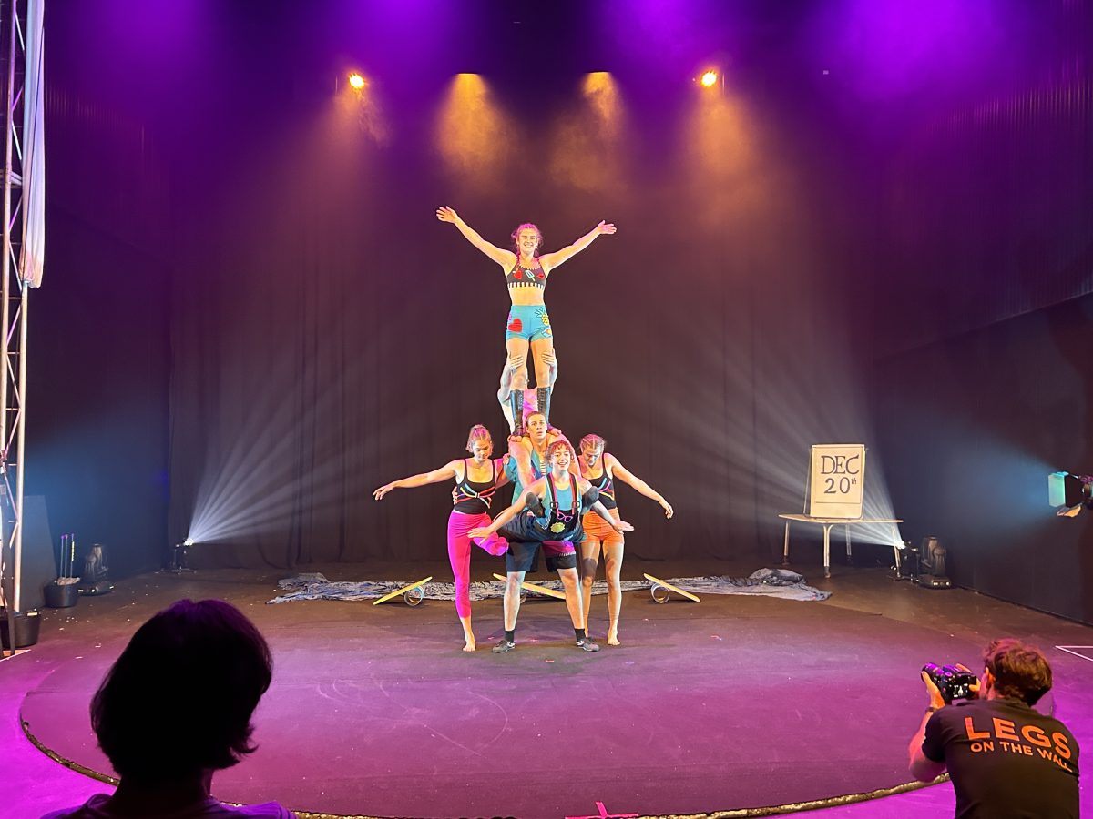 Group of circus performers stand on each others shoulders