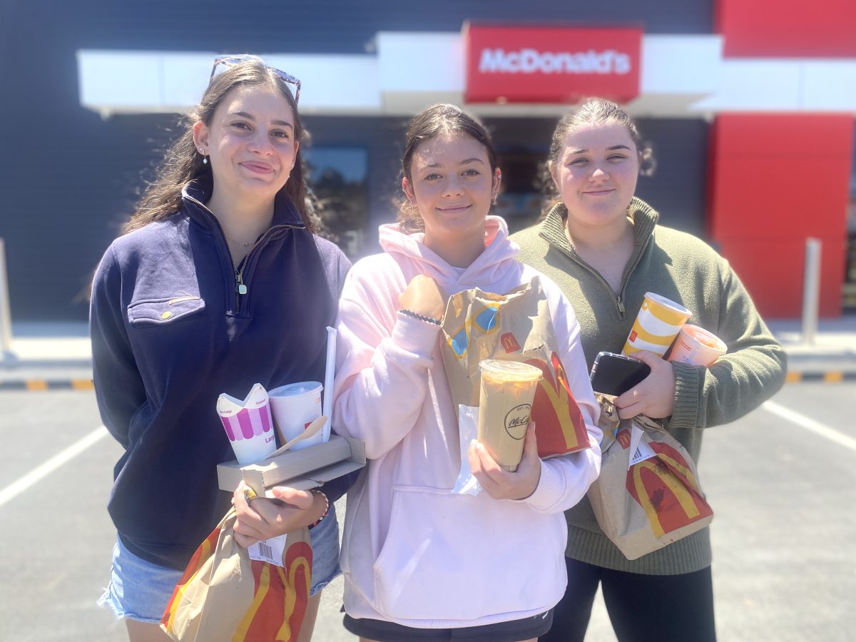 three teenage girls with fast food