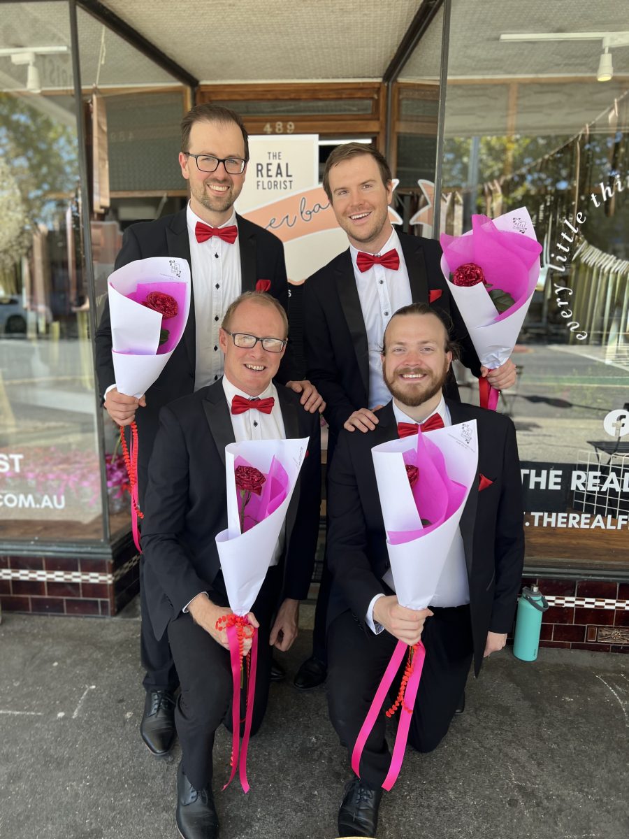 barbershop quartet holding bunches of flowers