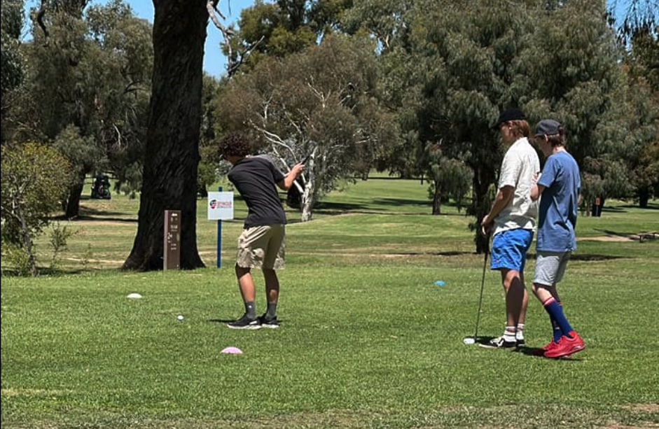 three young men playing golf