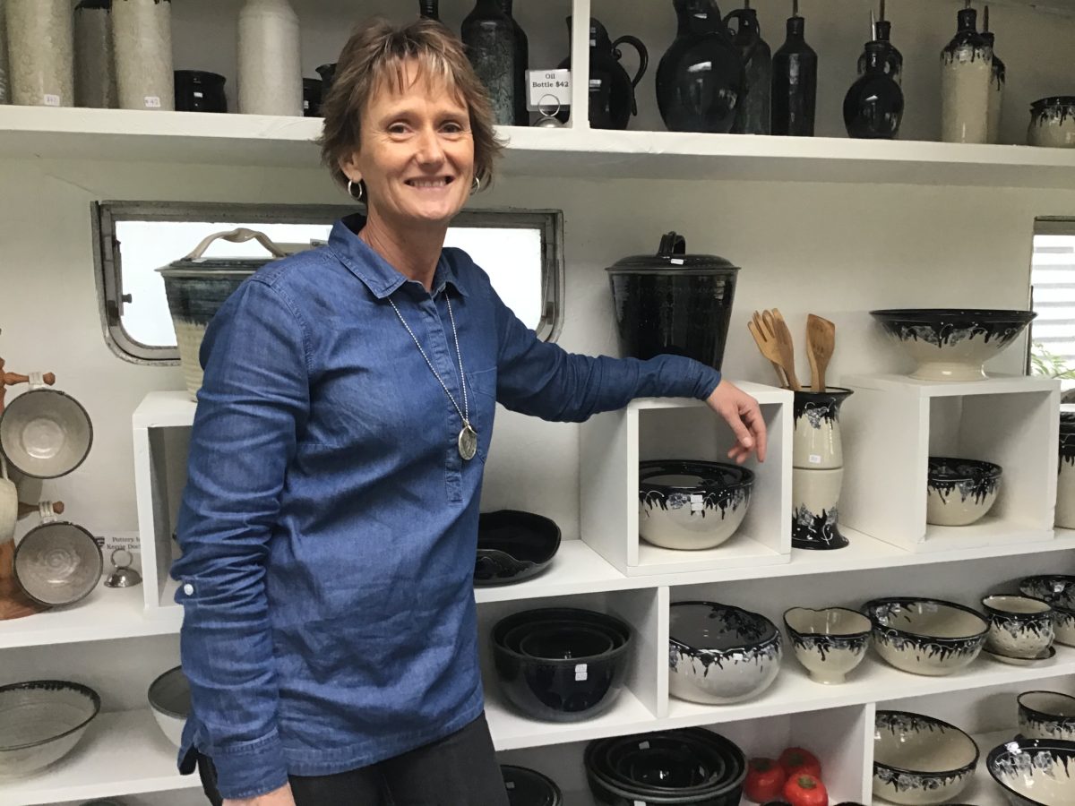 Woman standing in her pottery gallery