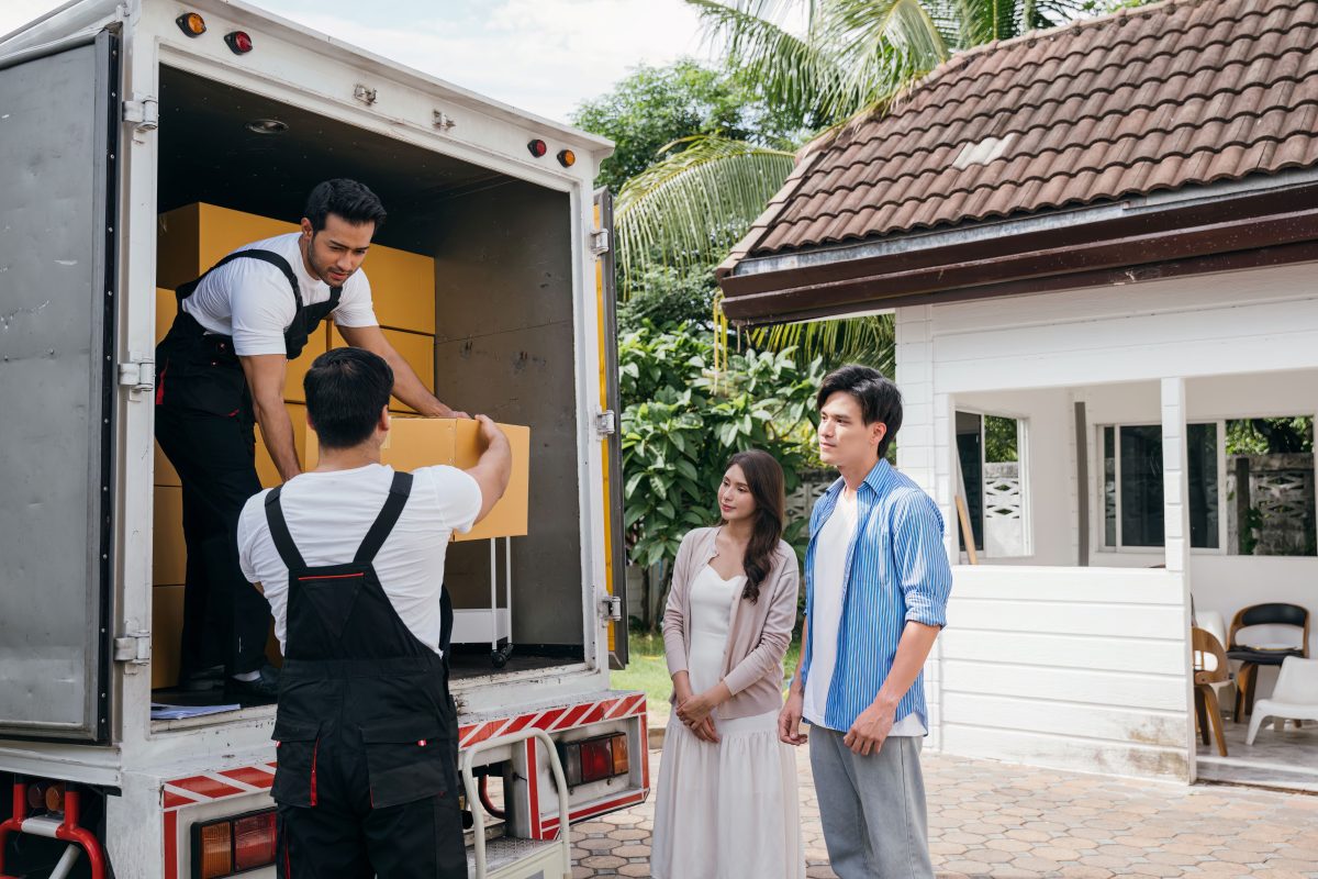 two removalists helping couple move in