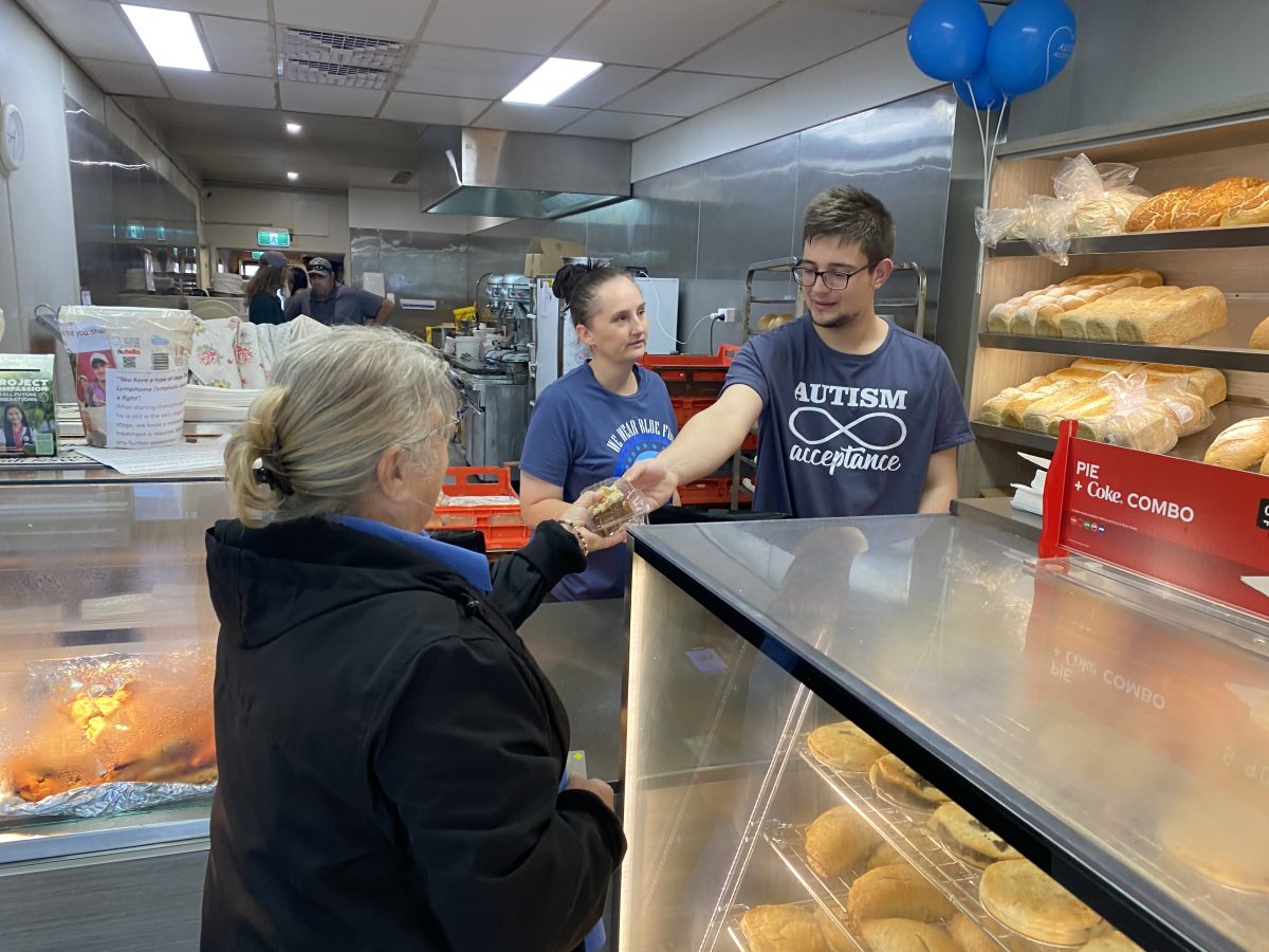 young man serves a customer at a bakery
