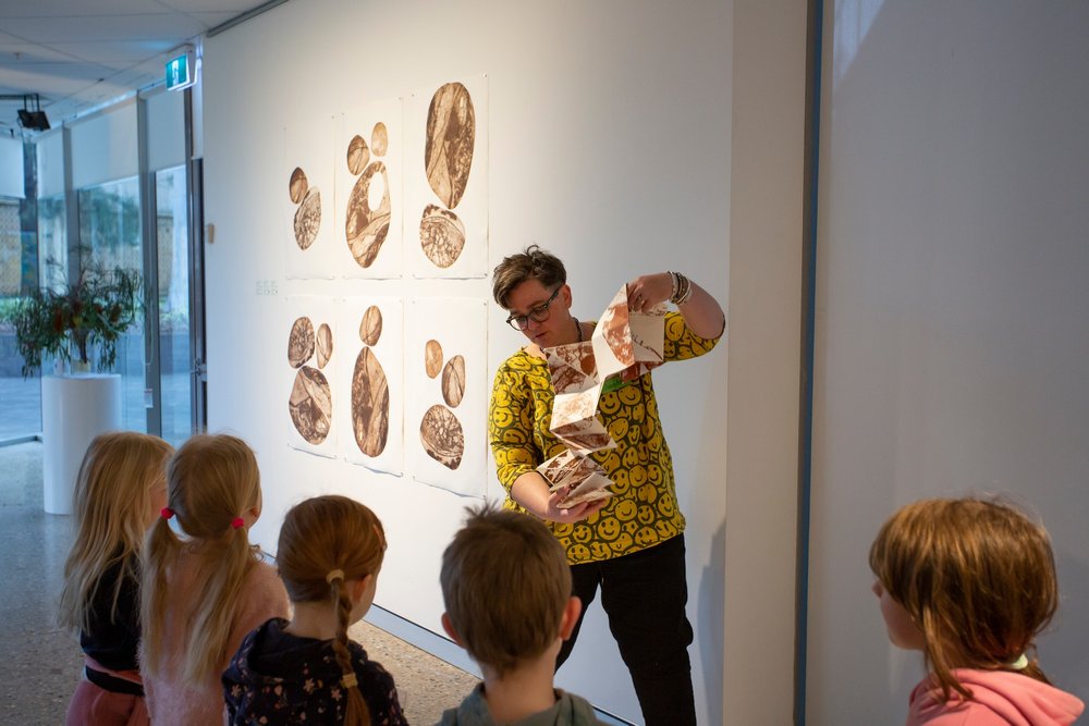 Juanita explains her work to a group of visiting children at the Wagga Wagga Art Gallery.