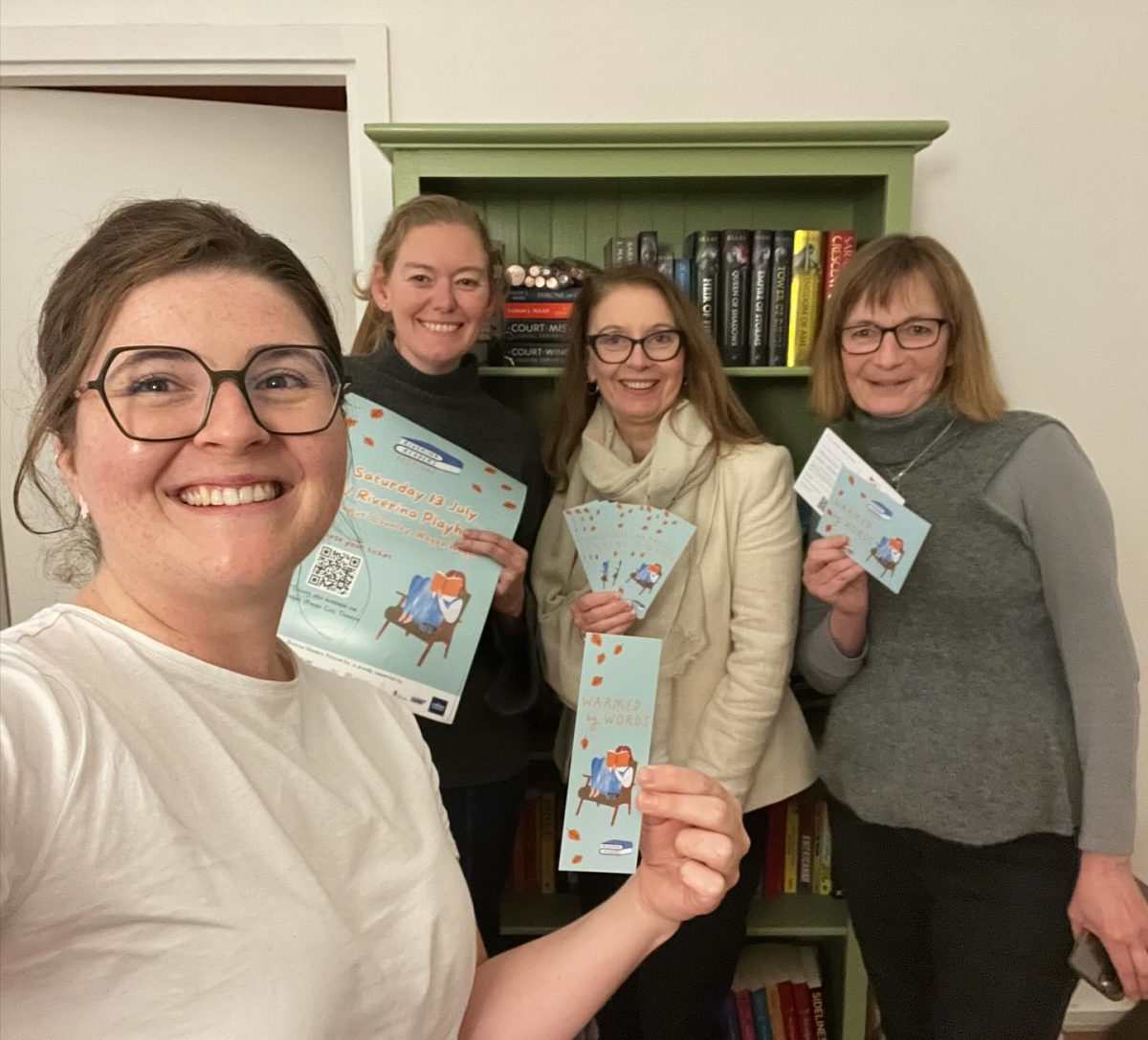four women with tickets and a brochure