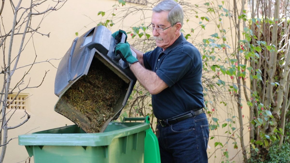 Man emptying lawn clippings in to bin