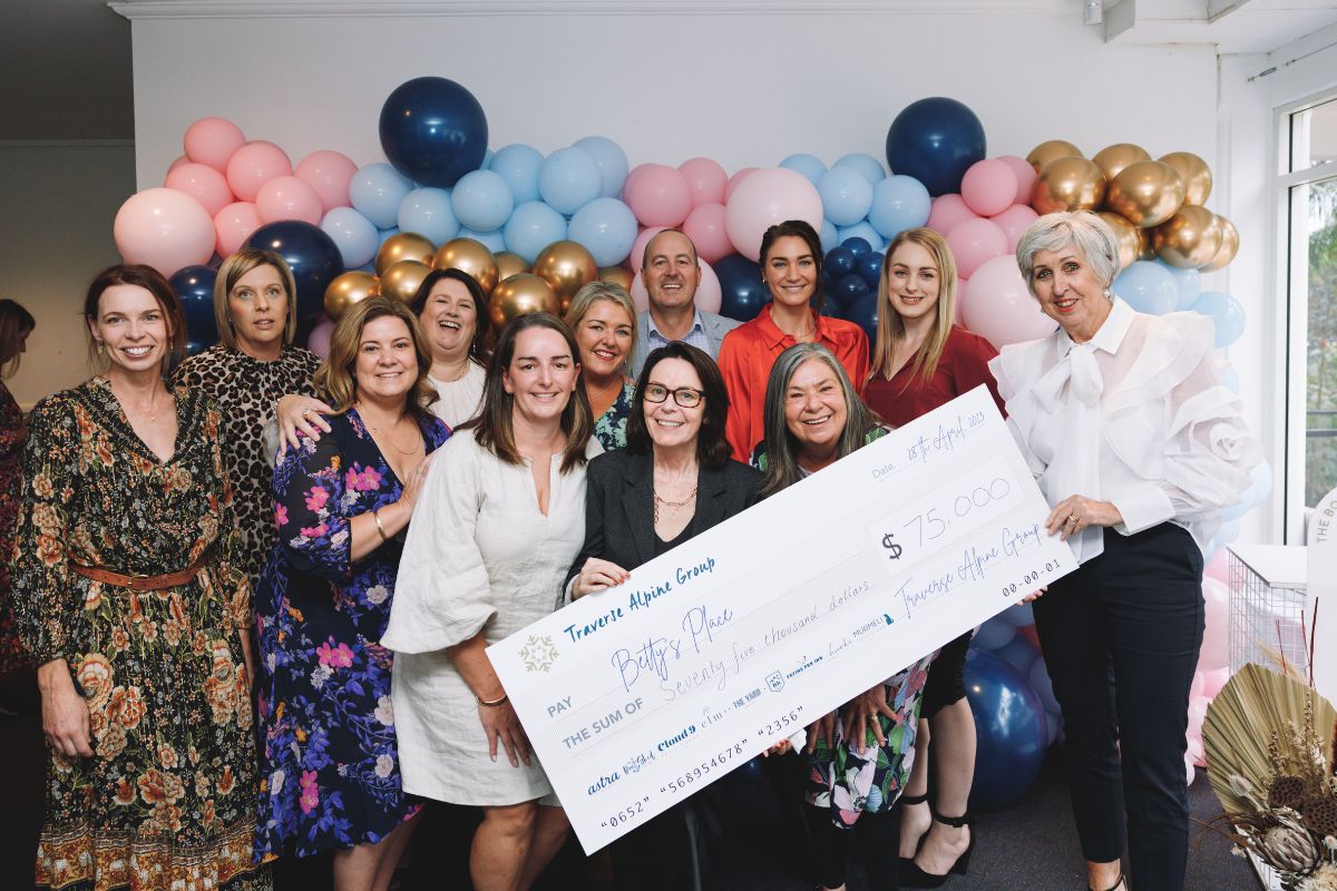 Group of people hold large fundraising cheque of $75,000