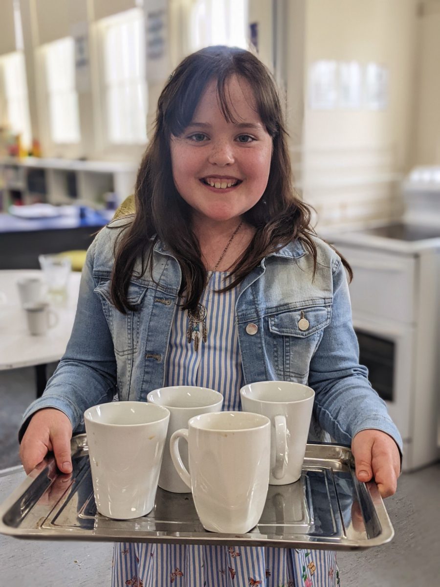 girl with tray of mugs in cafe