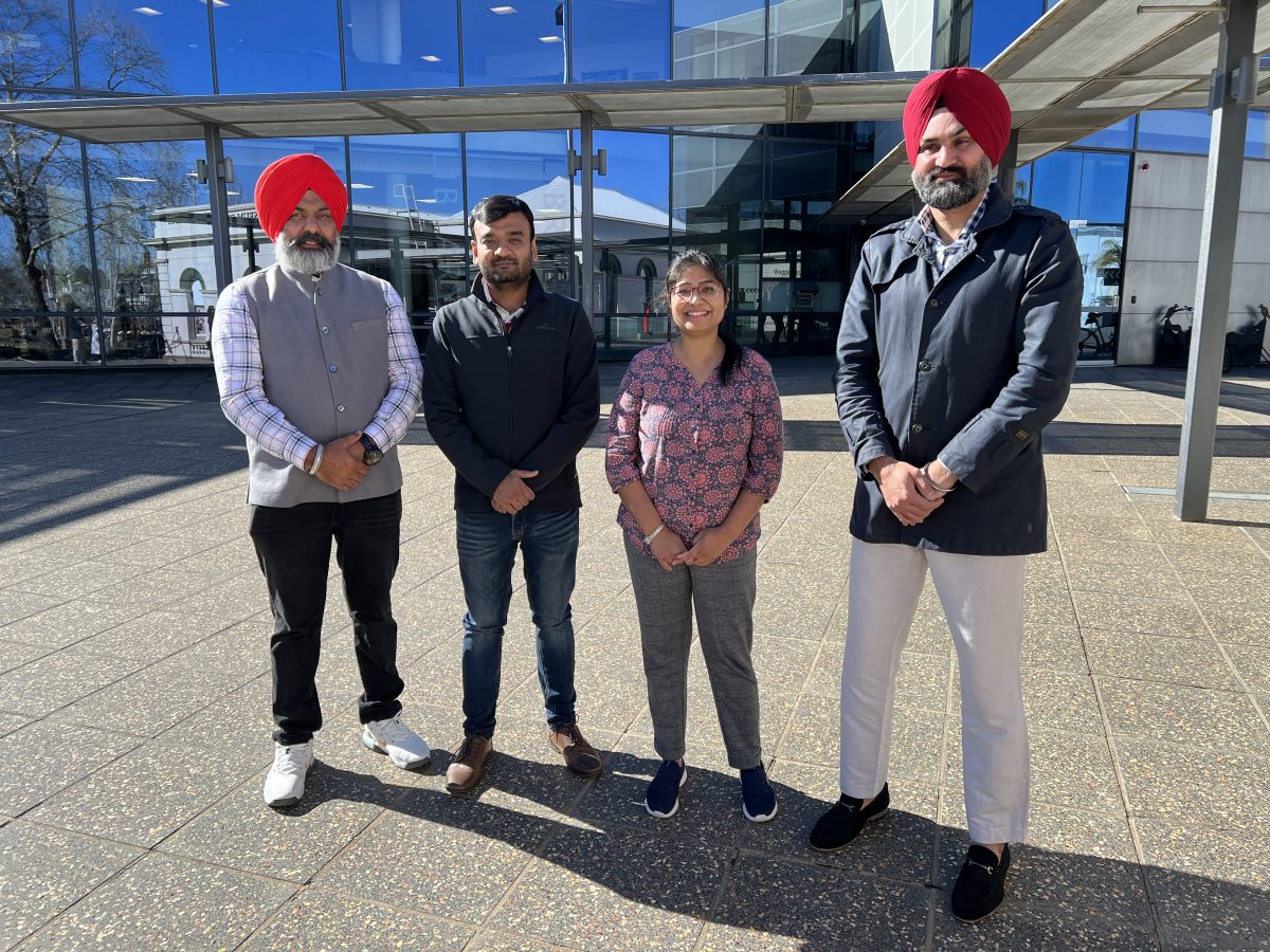 four people standing outside a building