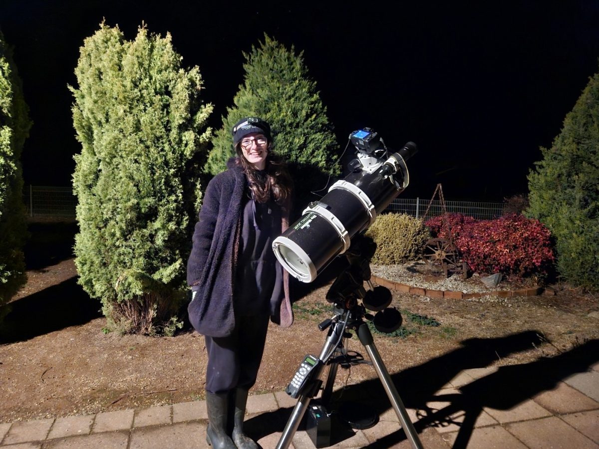 Woman in front of star gazing telescope