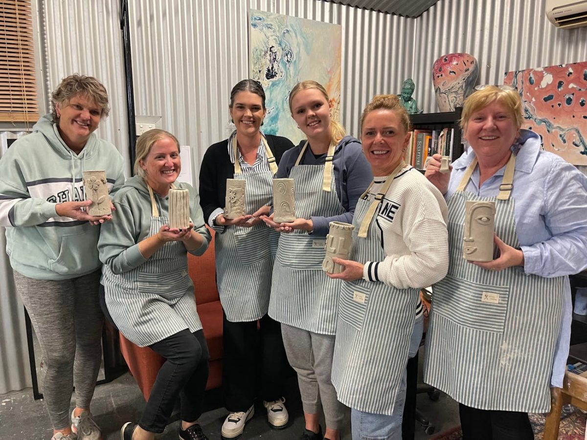 a group of women holding pottery