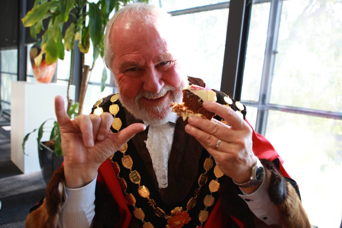 Former mayor Rod Kendall eating cake. 