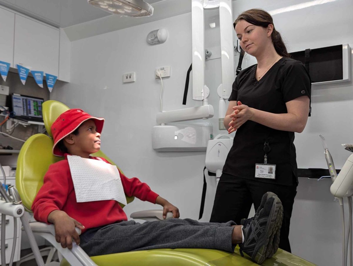 Mount Austin Public School student Birrani Barlow gets his teeth checked by oral health therapist Hope Pressler. 