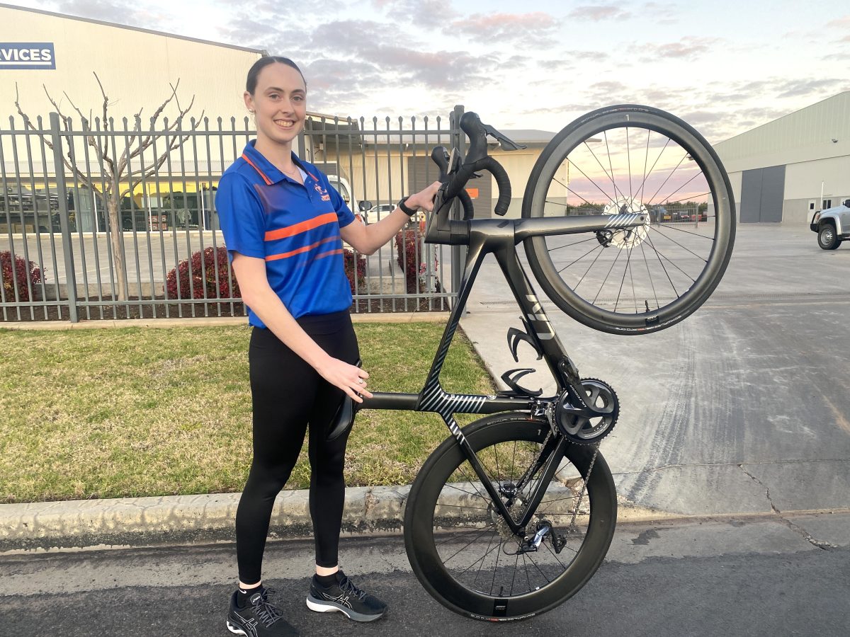 Girl holding bike on one wheel 