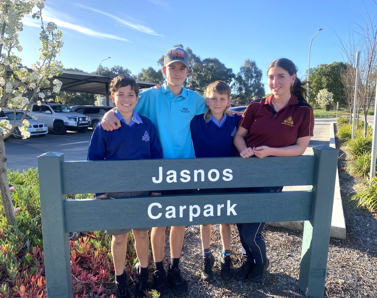 Four kids behind Jasnos sign