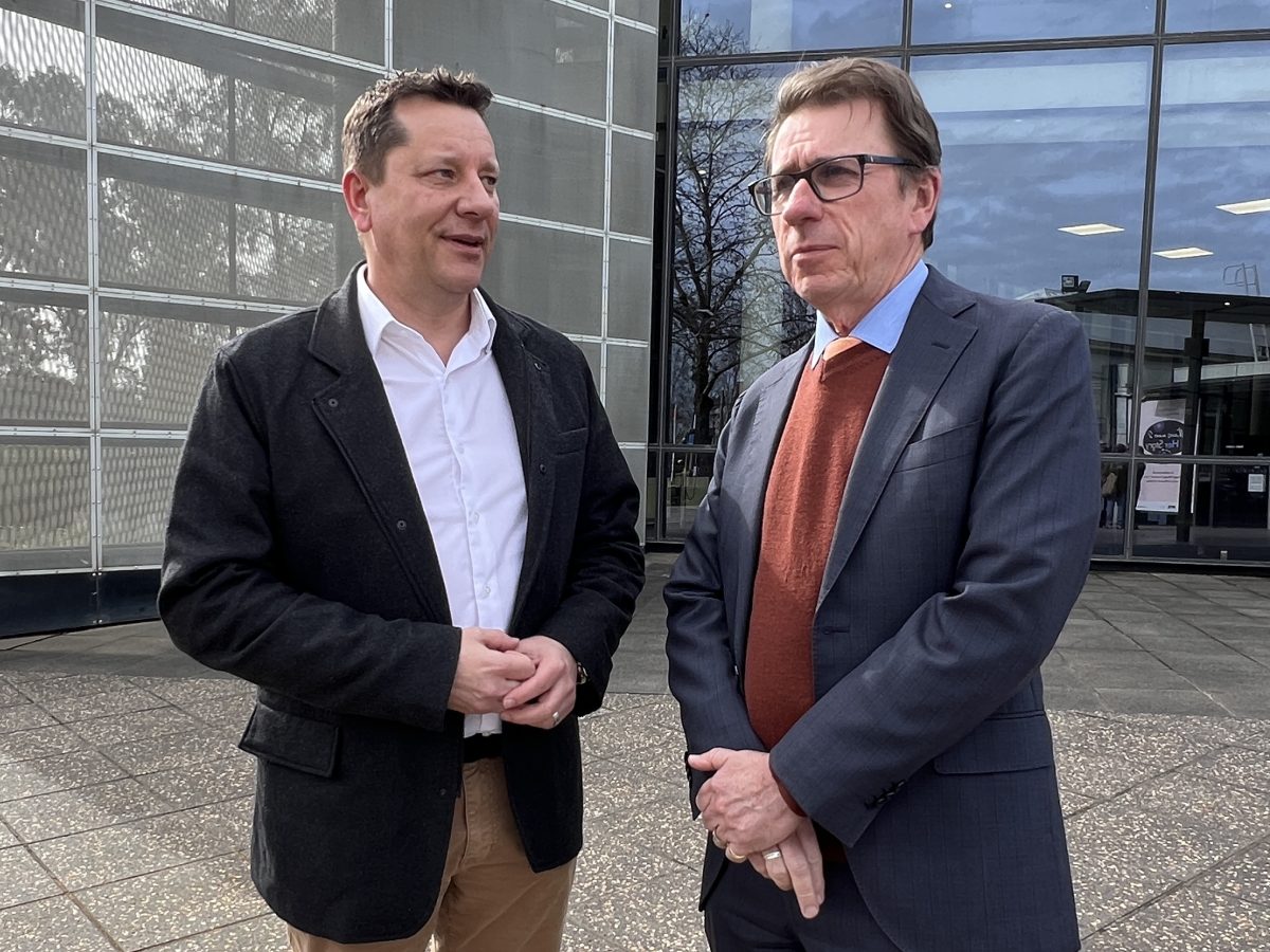 two men standing outside a building