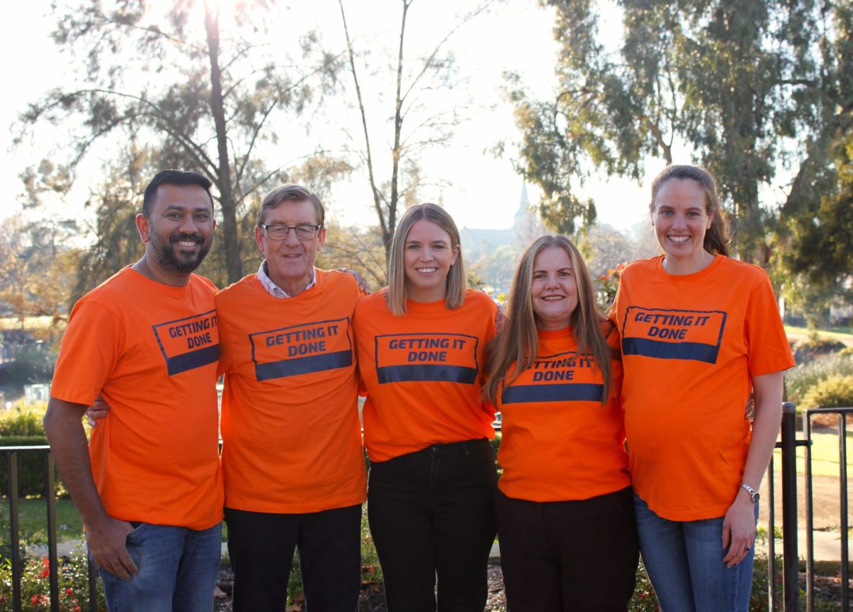 Group of five people in orange shirts