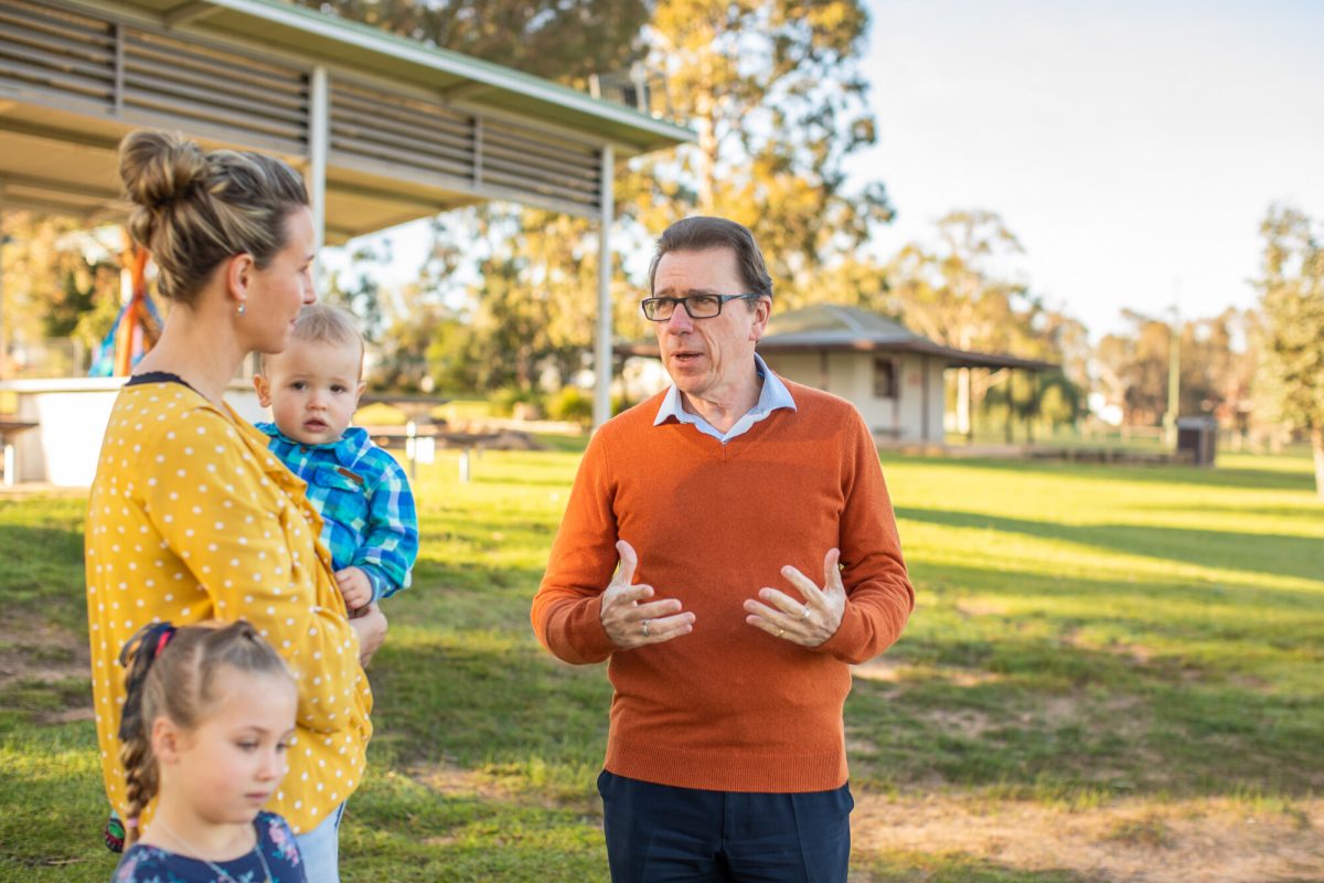 Man speaking to woman with kids