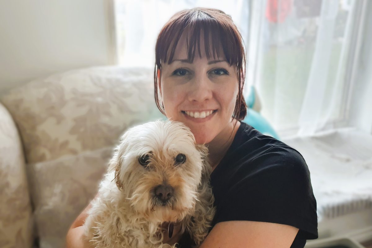 Woman holding her white fluffy dog