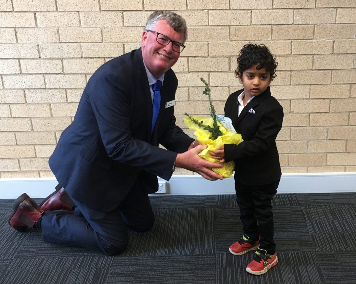 man giving a boy a plant