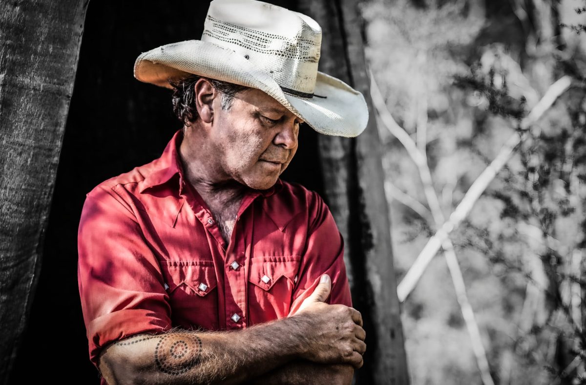 Troy Cassar-Daley standing in a field. 