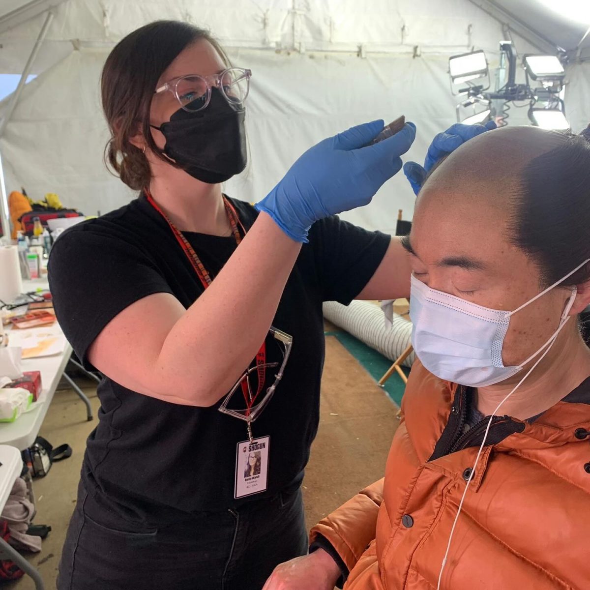 Woman applying makeup to actor 