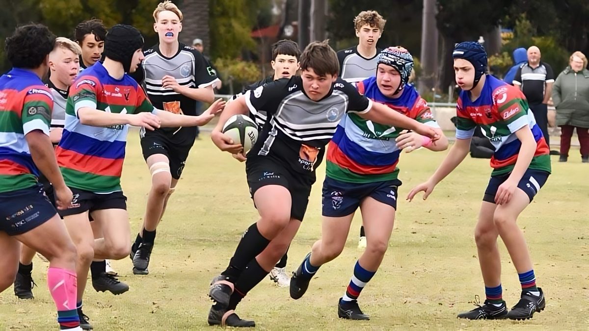 Rugby player breaking through tackle 