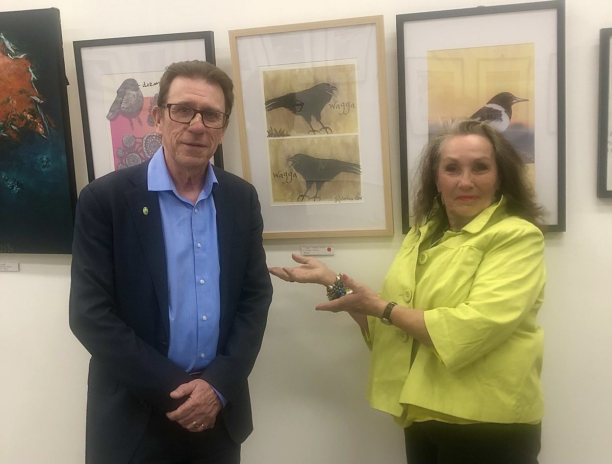 A man and a woman standing near art on display