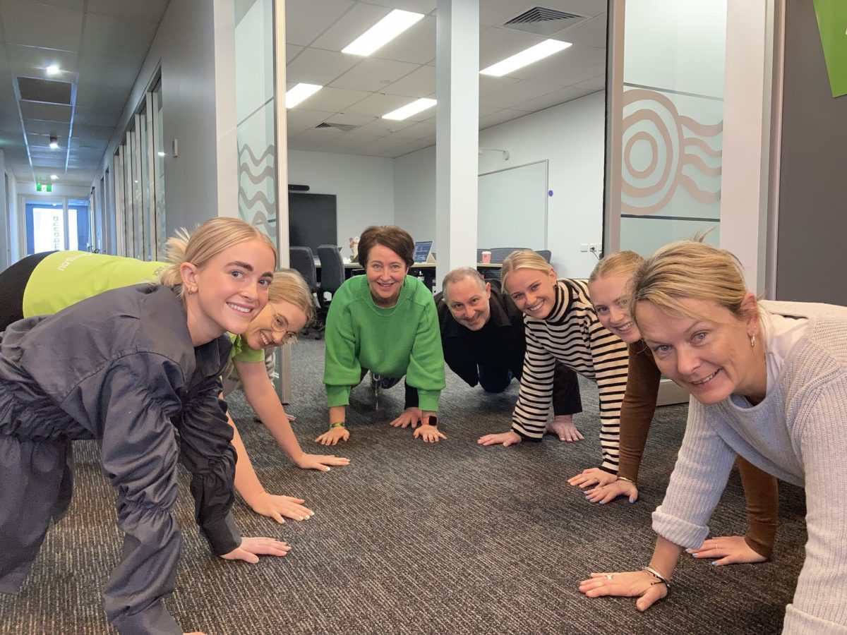 people doing push-ups in an office