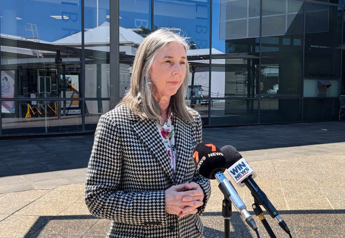 woman addressing the media outside a building