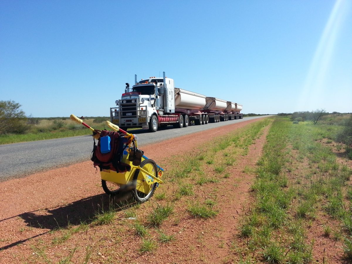 A road train passes by.