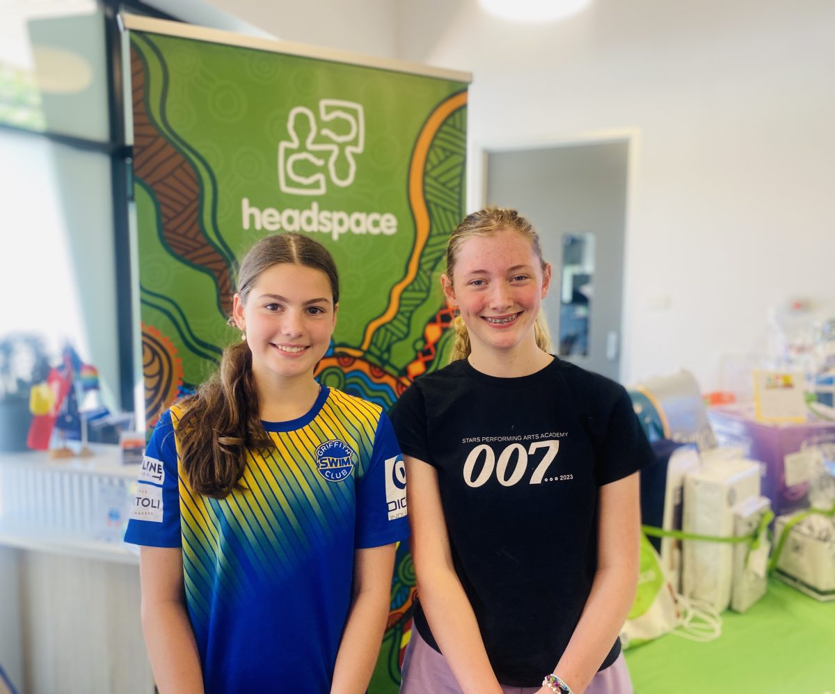 two girls in front of banner 