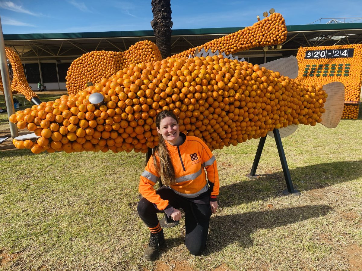 Woman and a citrus sculpture of a Murray cod