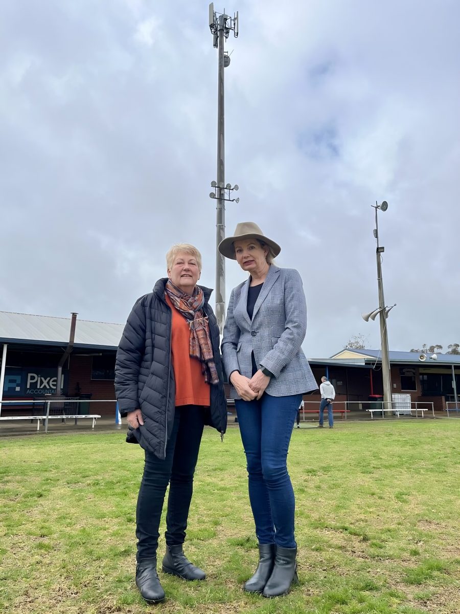 Two women under mobile phone tower 