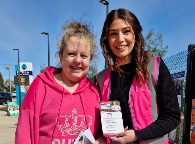 young woman giving an older woman an election flyer