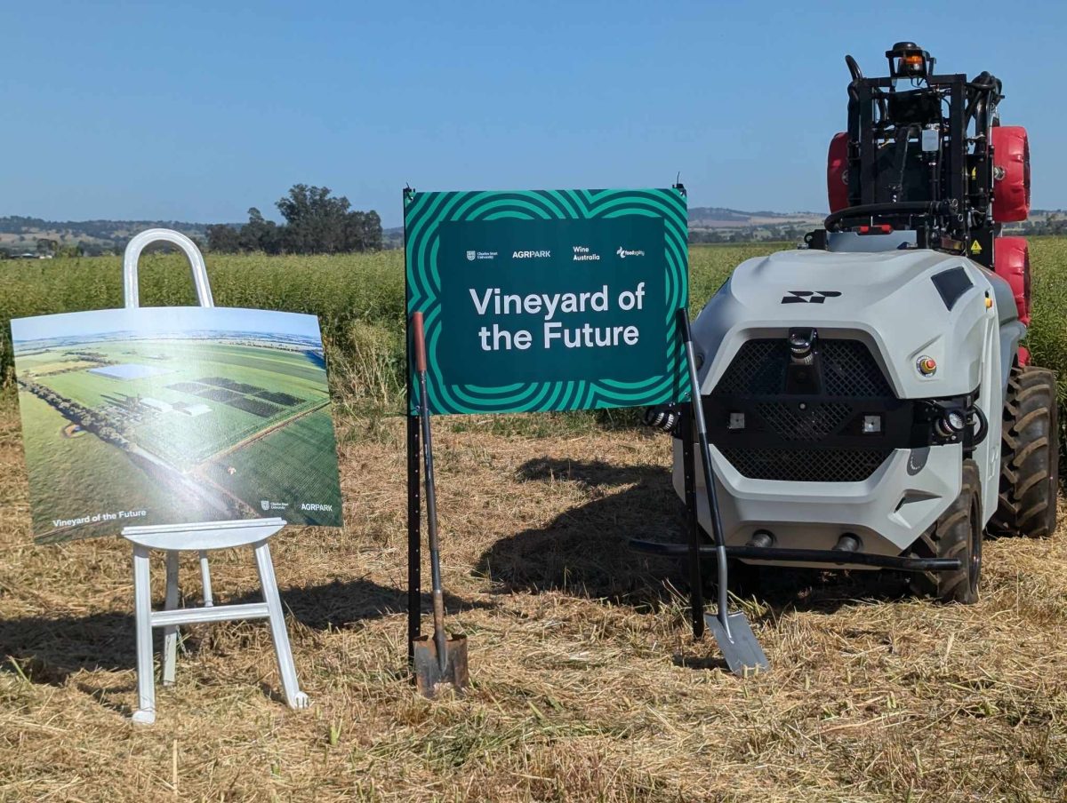 a tractor and signs on a vineyard