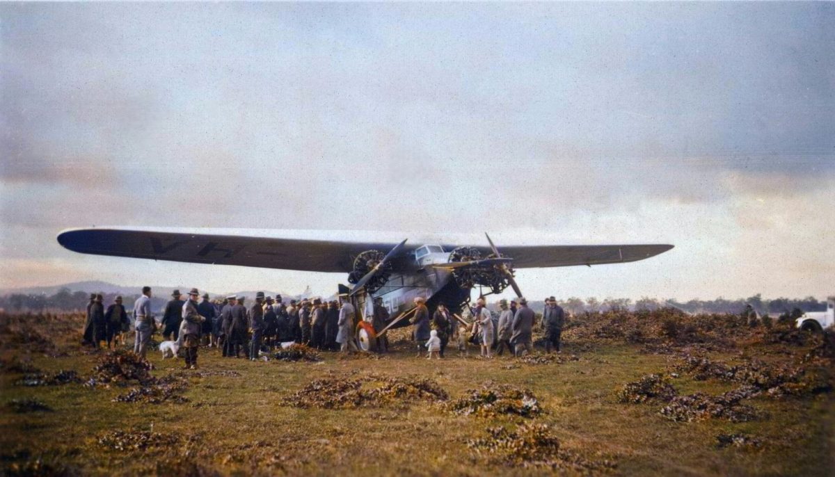 The Southern Cross with excited onlookers after landing at Oura. 