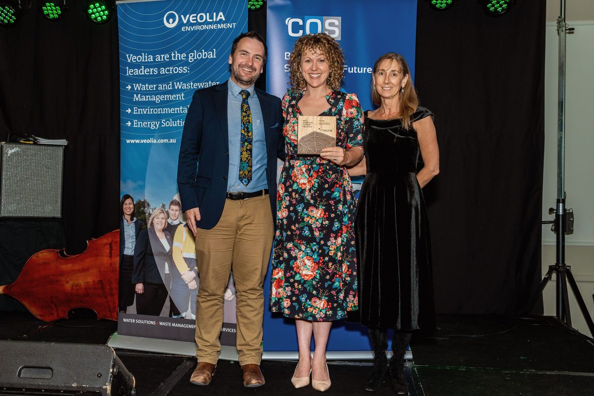 a man and two women on stage with an award