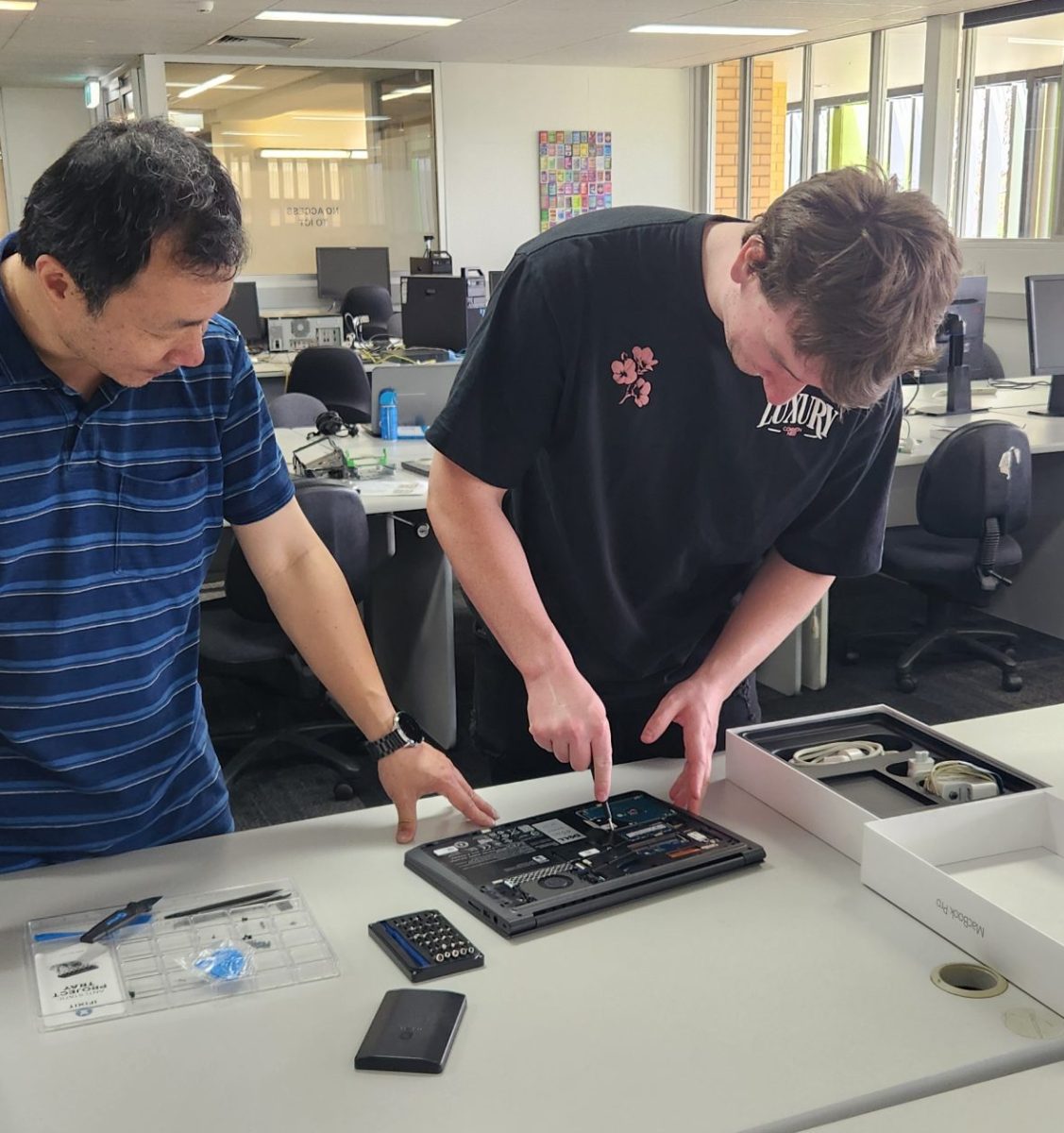 Teacher Kevin Liao works with student Ashton Carmody in a project that sees unwanted laptops get a new lease of life and distributed to people in the community in need of access to technology. 