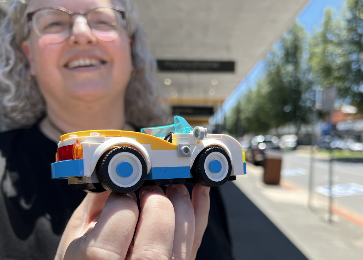 a woman holding a Lego car