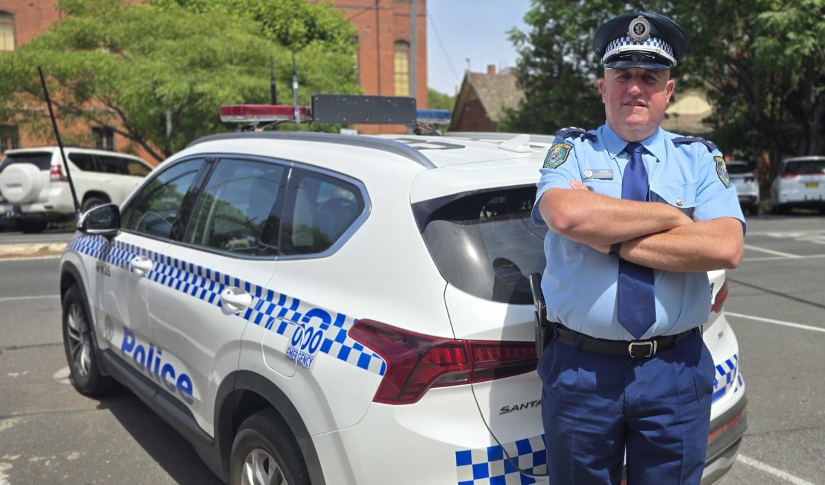 policeman leaning against a police car