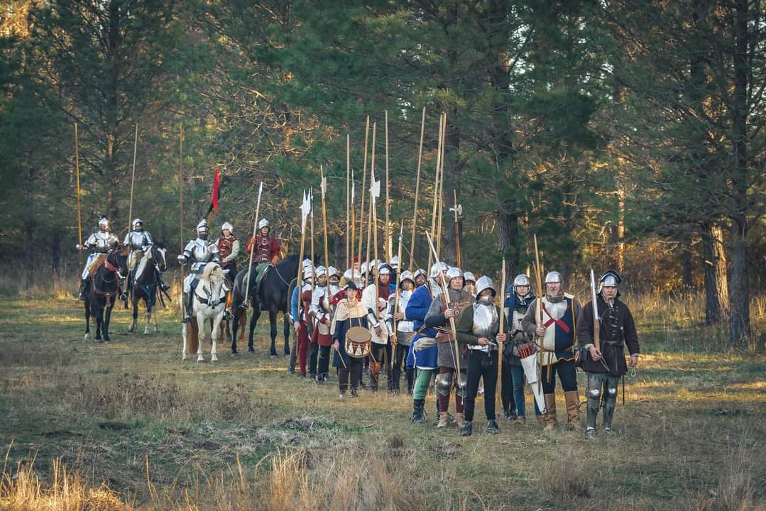 people in medieval garb, with jousting sticks and on horseback 