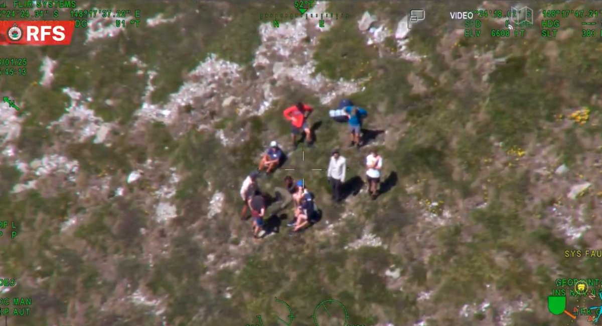 An aerial perspective of the moment authorities arrived to collect the missing student as he sat with the hikers who found him.