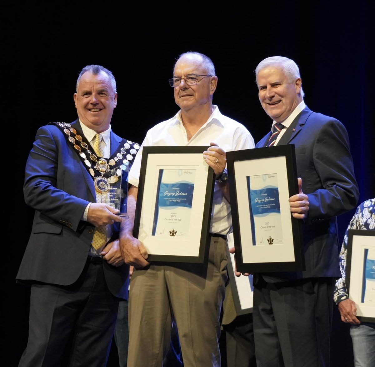 three men on a stage with awards