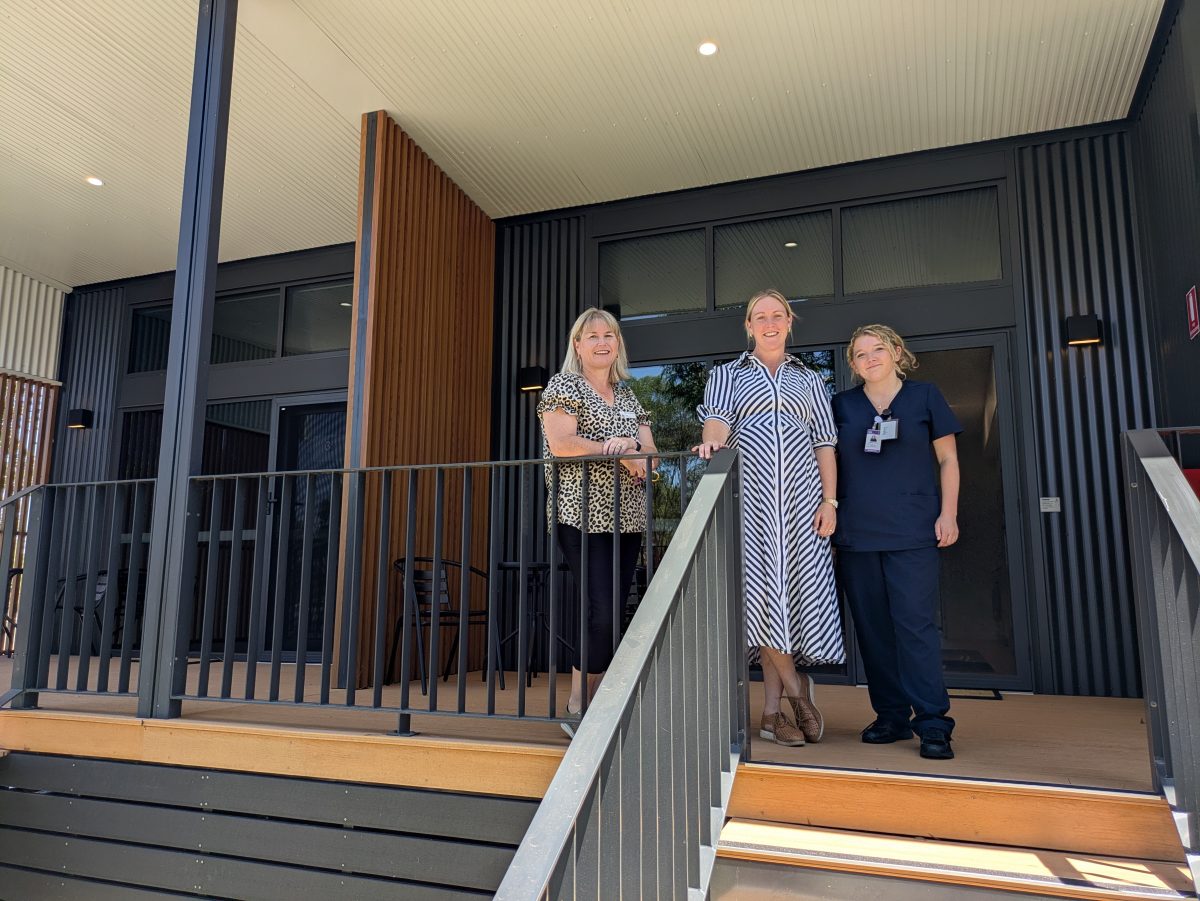 Three nurses in front of housing