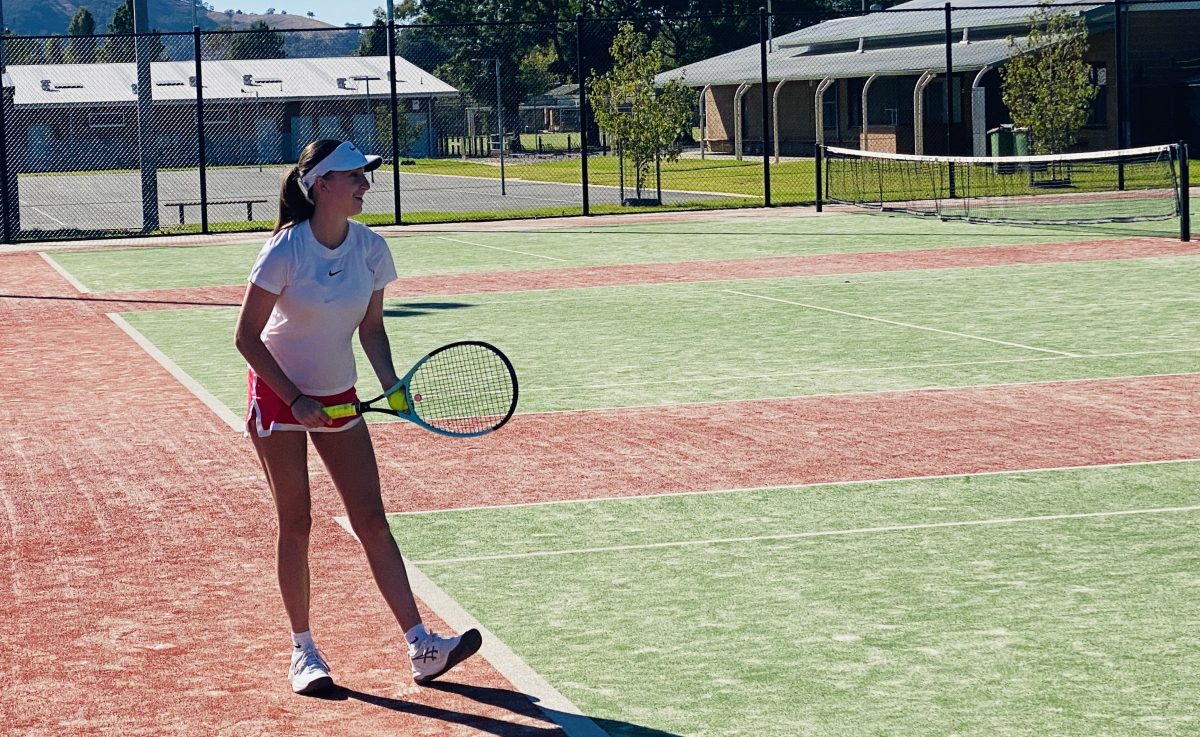 teenage female tennis player serving